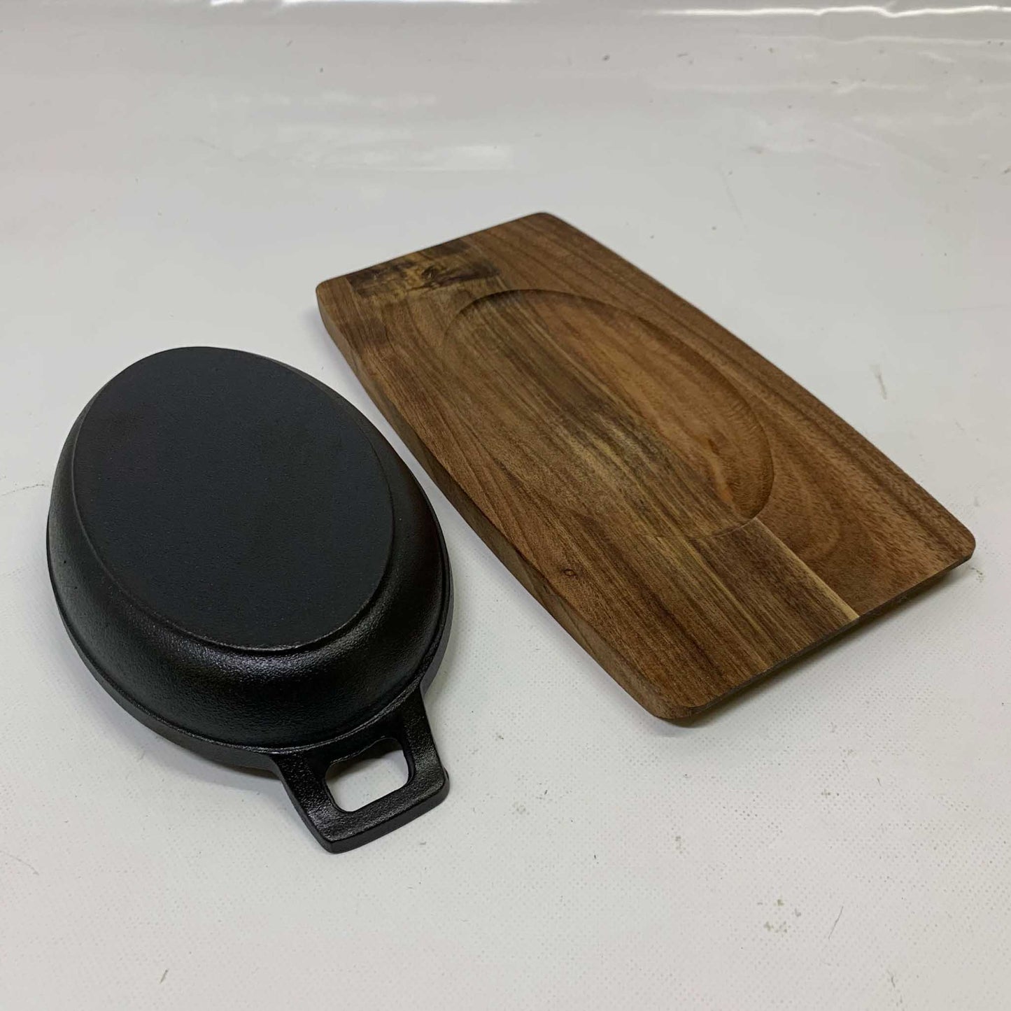 Gusseisen Grillpfännchen Ø 18cm mit Servierbrett, ideal für Grillgerichte, hitzebeständig, gleichmäßige Wärmeverteilung.